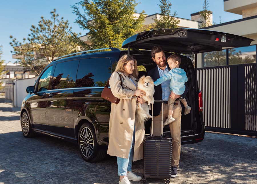 Familly by minivan with luggage and boot door open
